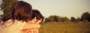 man and woman hugging in grass field