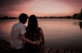 man and woman in front of sunset and water