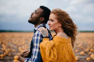 Woman holding a man's shoulder in a field