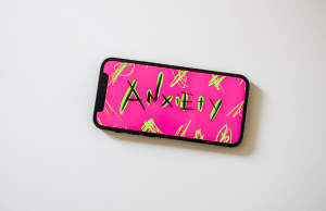 Black and green anxiety lettering with a pink background on phone screen