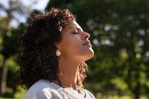 Woman facing the sun with her eyes closed