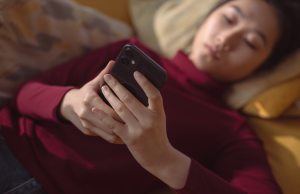 woman-in-red-shirt-holding-black-smartphone