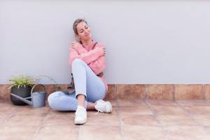 Woman on the floor hugging herself