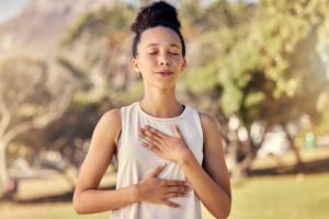 Woman holding her hands to her sternum