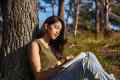 Young woman journaling by a tree