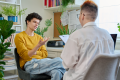 Young male patient in therapy with psychologist counselor in office